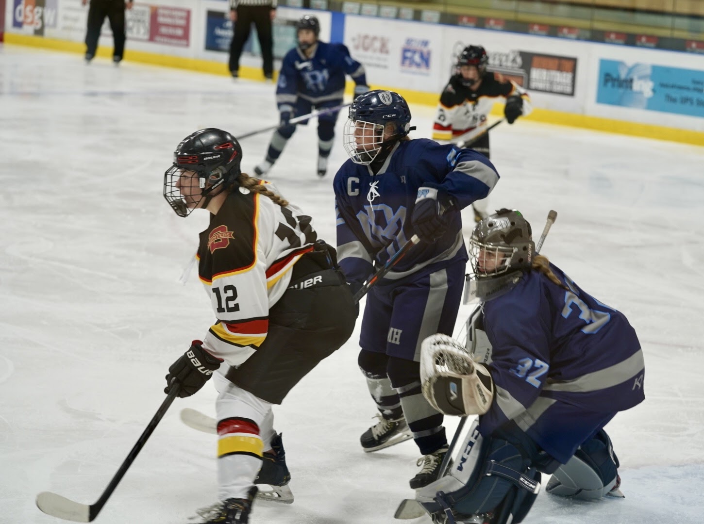 Roseville/Mahtomedi goaltender Lily Peterson and defender Lexi Jensen guard the net in front of Duluth's Jenna Horvat.